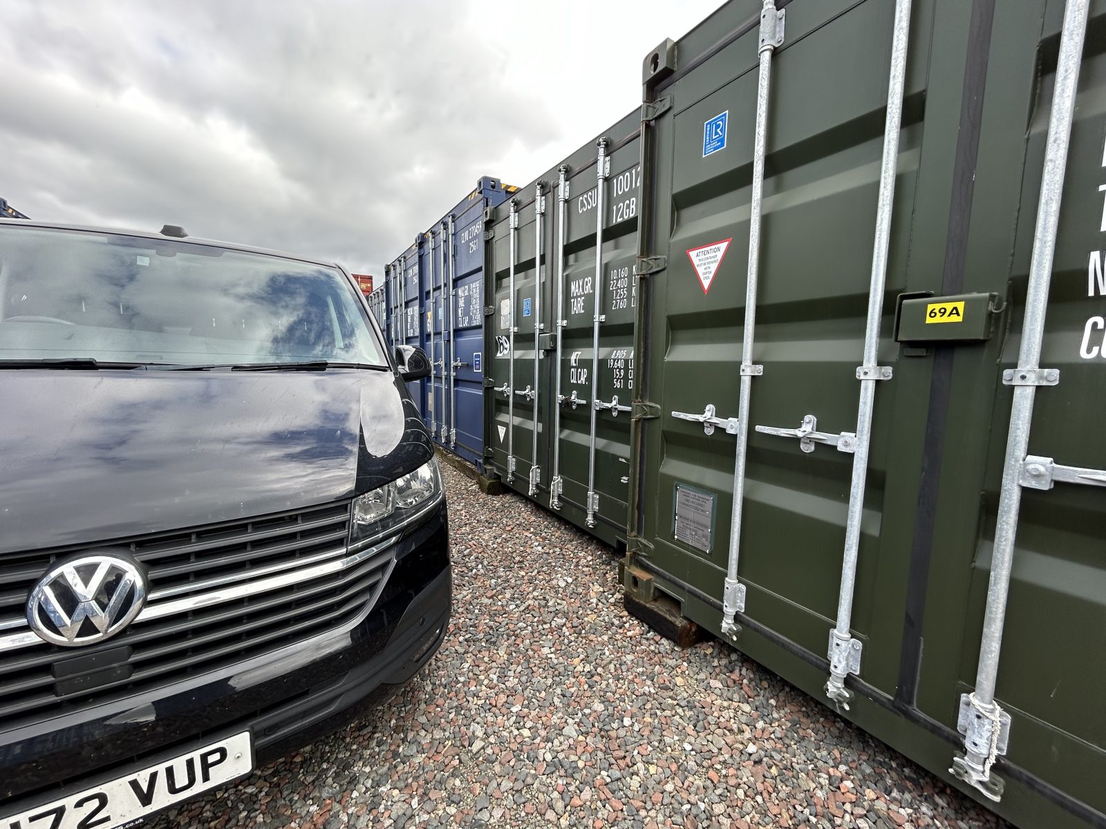 a van parked beside a row of shipping container storage units