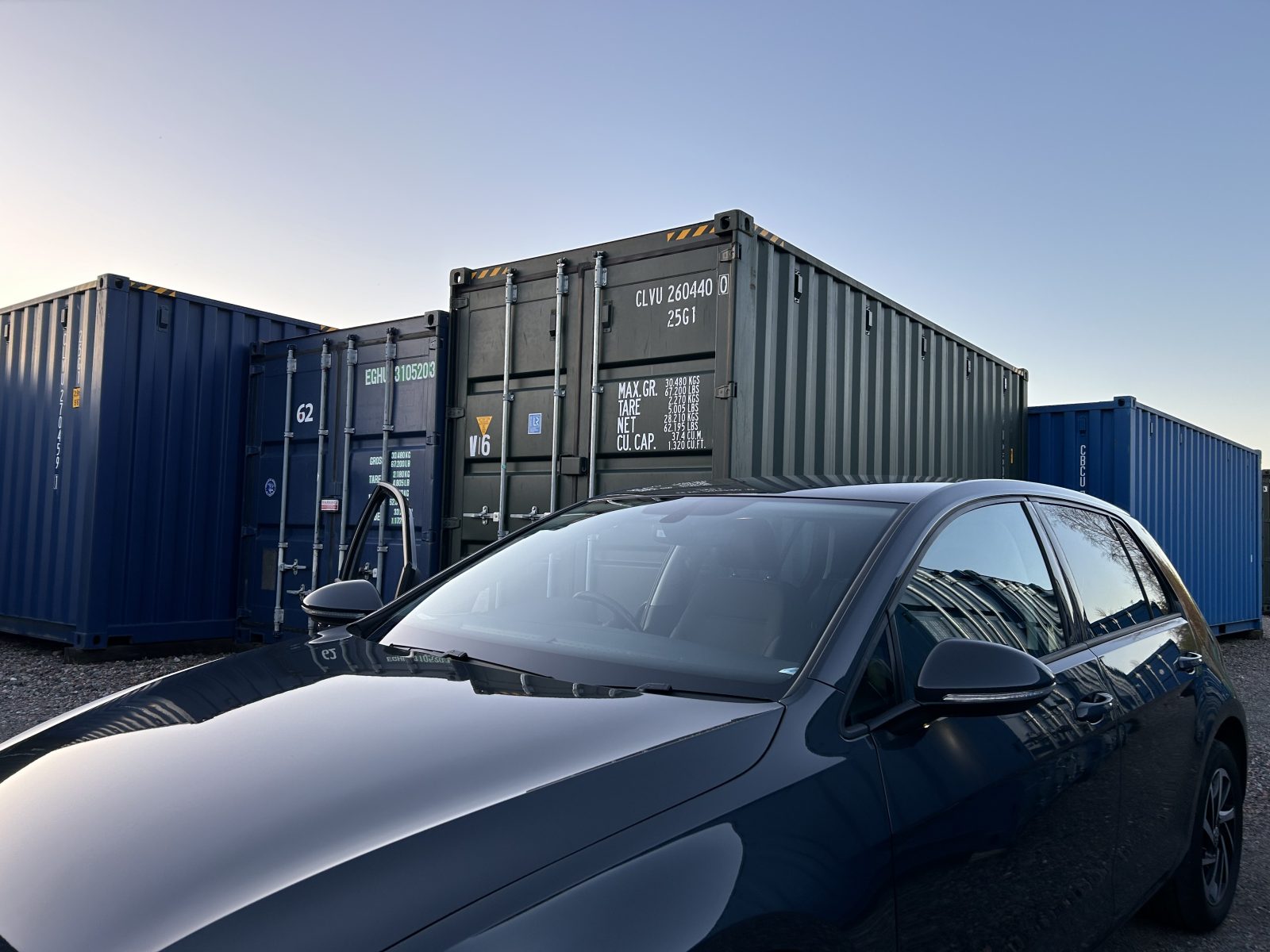 a car parked beside self storage container units