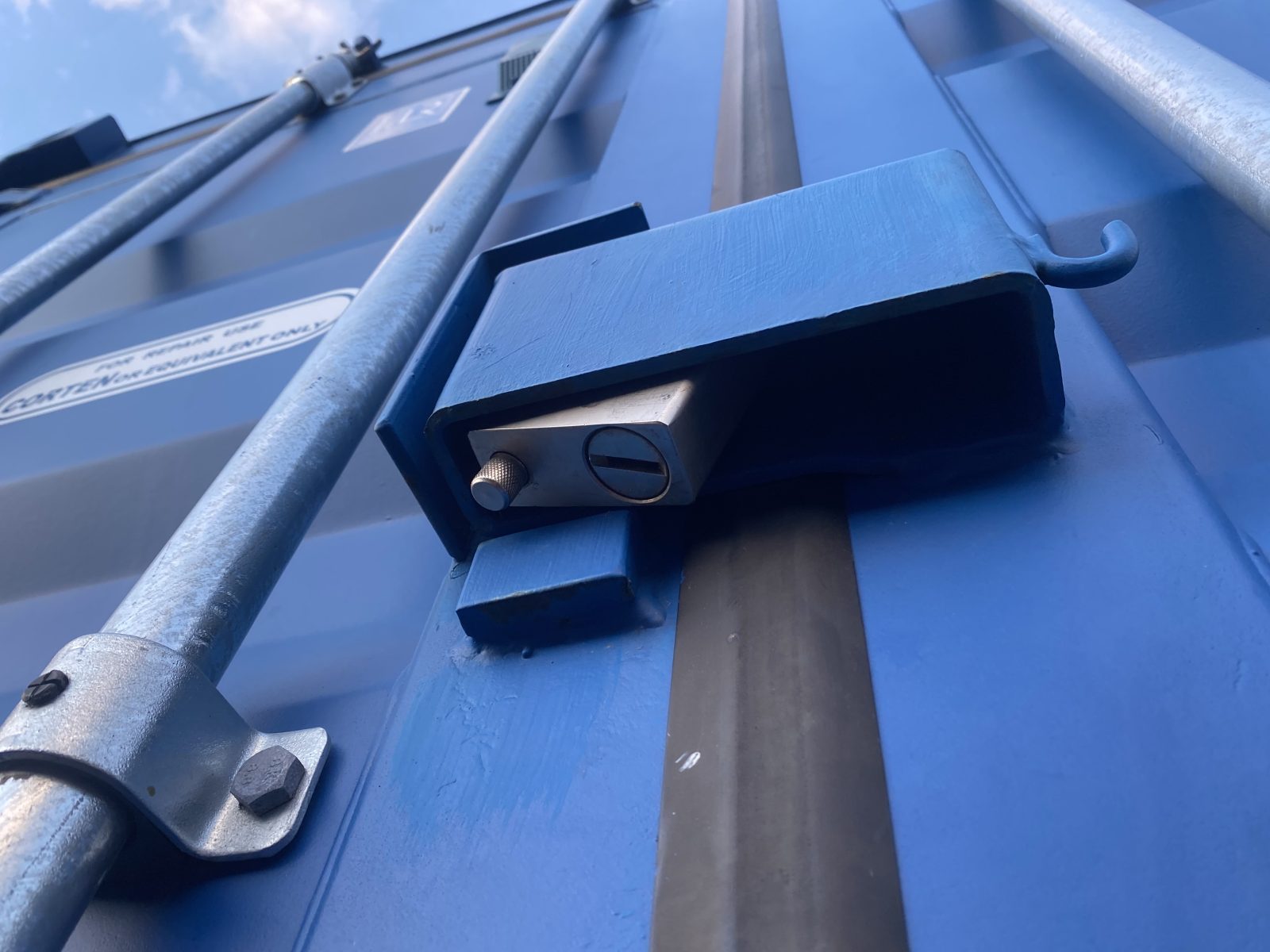 a padlock fitted to the lock box of a blue shipping container