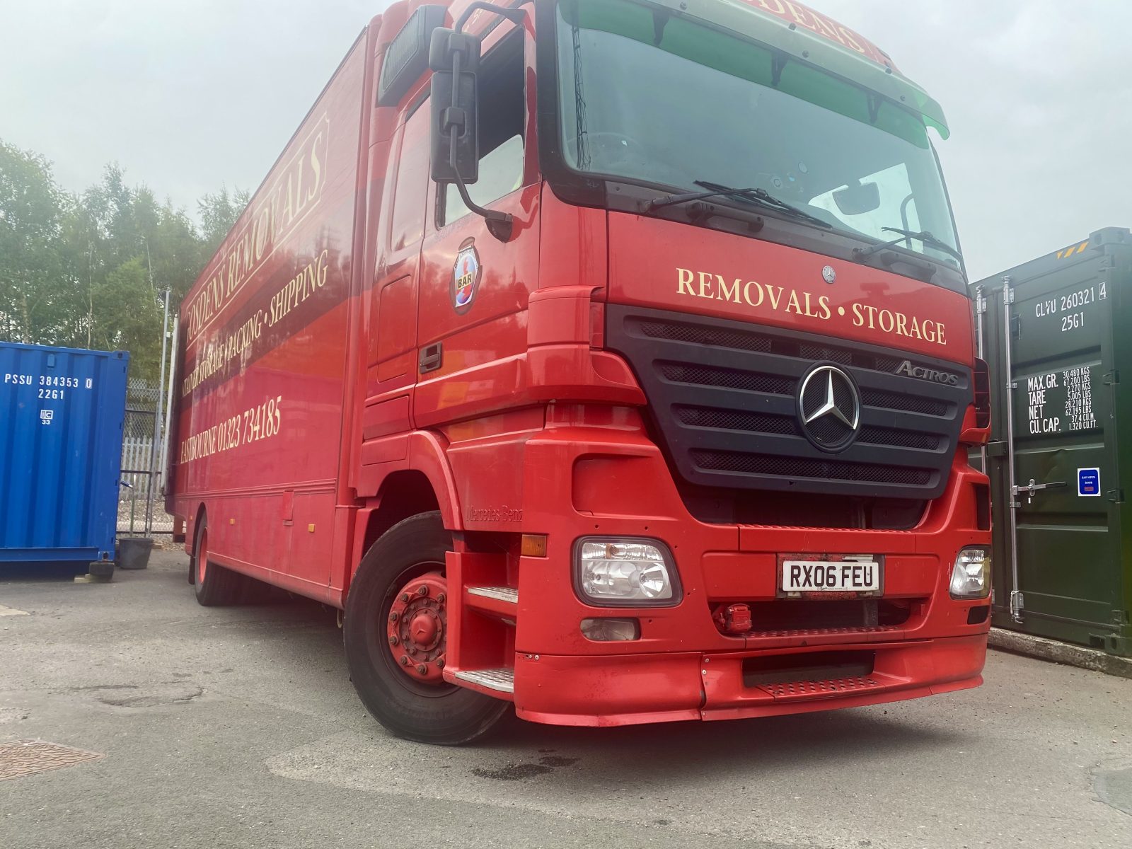 Large removal vehicle unloading on storage facility